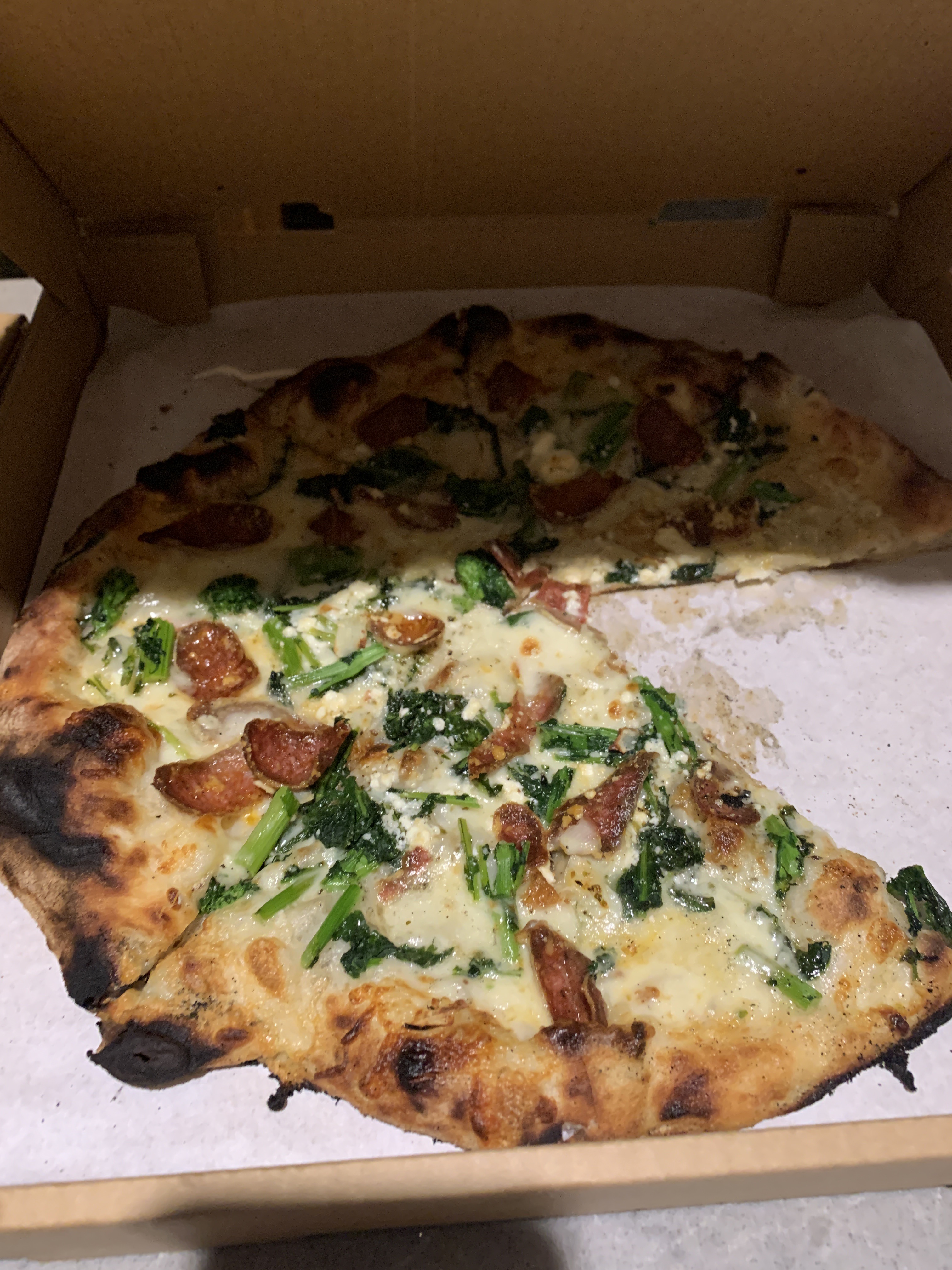 White pie with broccoli rabe and sausage from Pazzo in San Carlos, California, with a leopard-charred crust in a pizza box